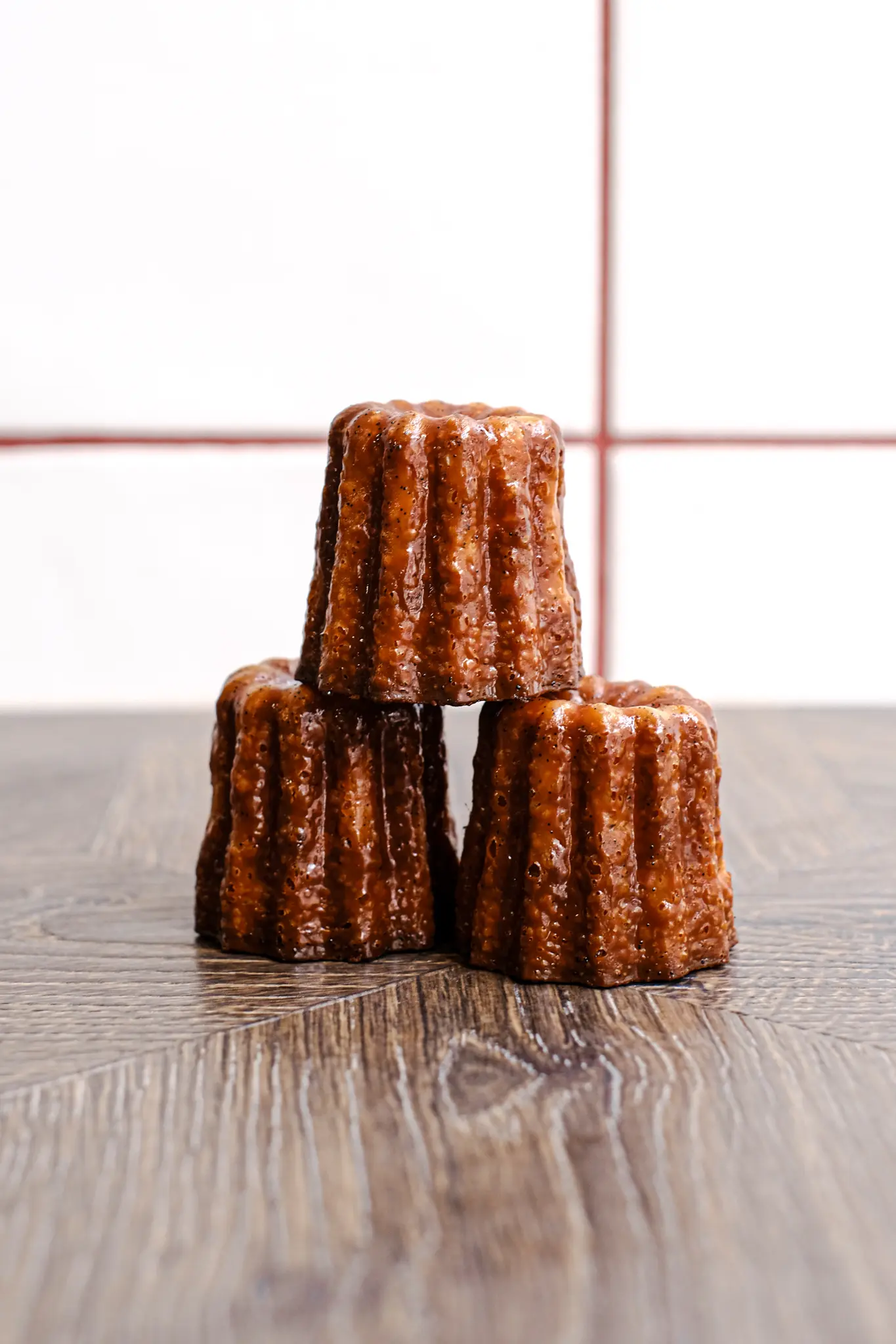 Vue rapprochée du dessus d’un cannelé bordelais, laissant apparaître la vanille et le caramel.